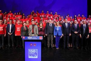 PES Vice President Andrzej Szejna (seventh from left), European Commission Executive Vice-President Frans Timmermans (nineth from left), PSD leader Marcel Ciolacu (eleventh from left), PES Vice President Victor Negrescu (twelfth from left), and PES Executive Secretary General Giacomo Filibeck (thirteenth from left) on stage with conference participants and PSD activists.
